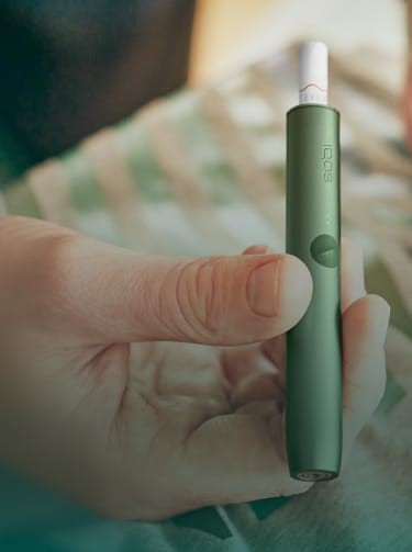A moss green IQOS ILUMA Holder and Pocket Charger.